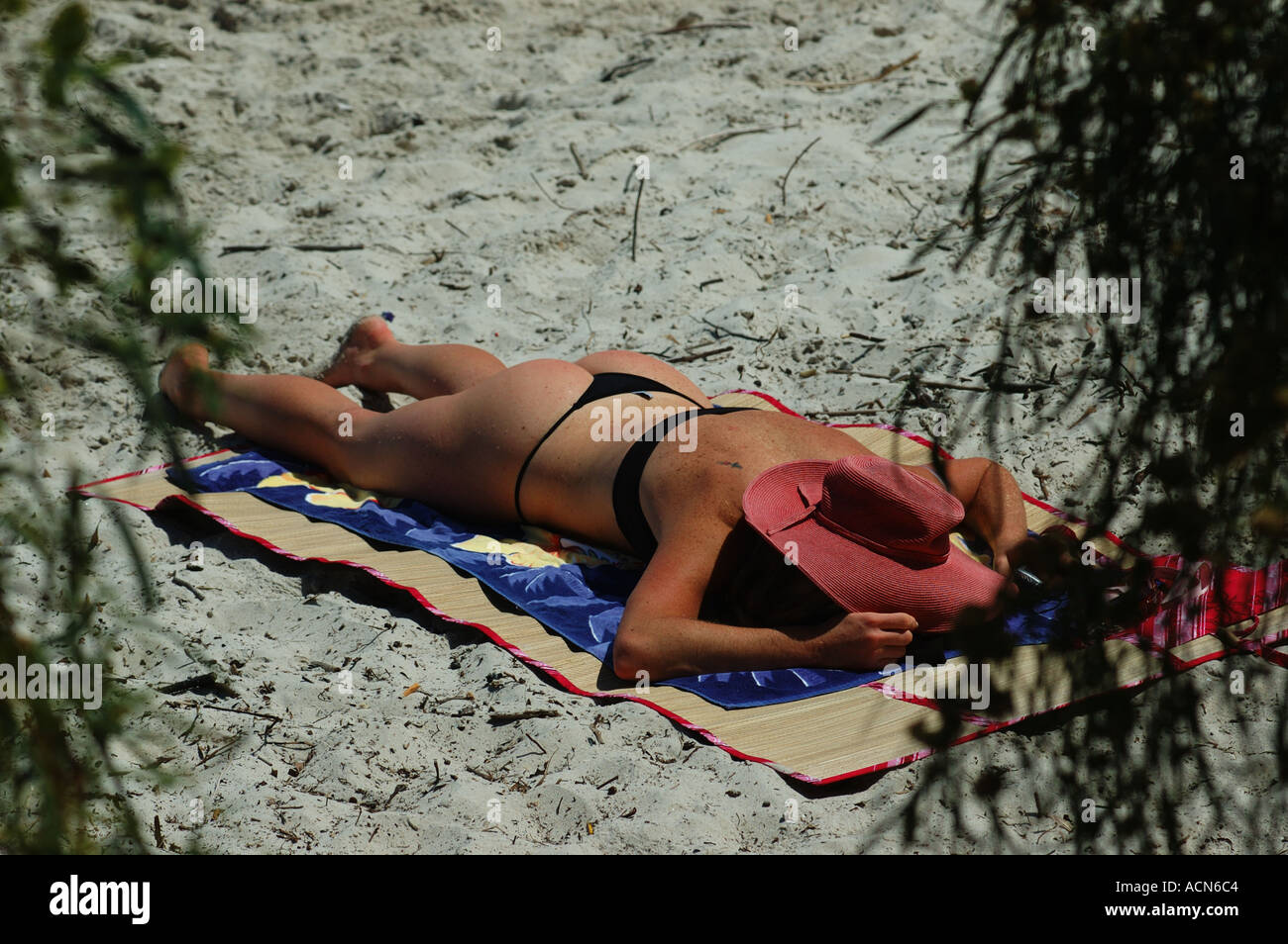 Young woman sunbakes alone on secluded beach dsc 5994 Stock Photo
