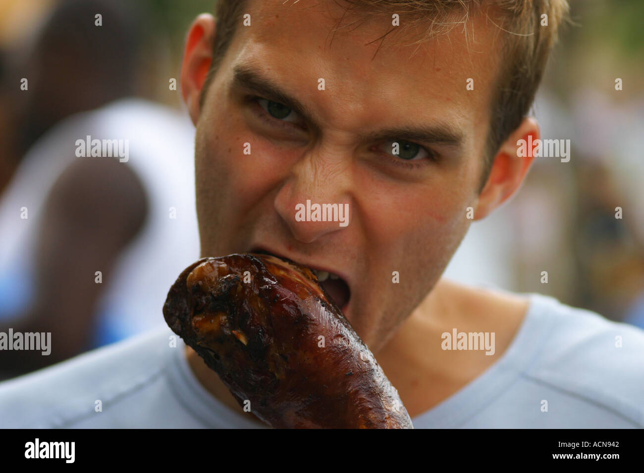 Young man eating ravenously turkey leg Stock Photo