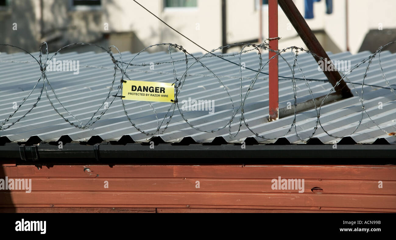 Razor wire security fixed on garage roof Newport Gwent South Wales UK Stock Photo