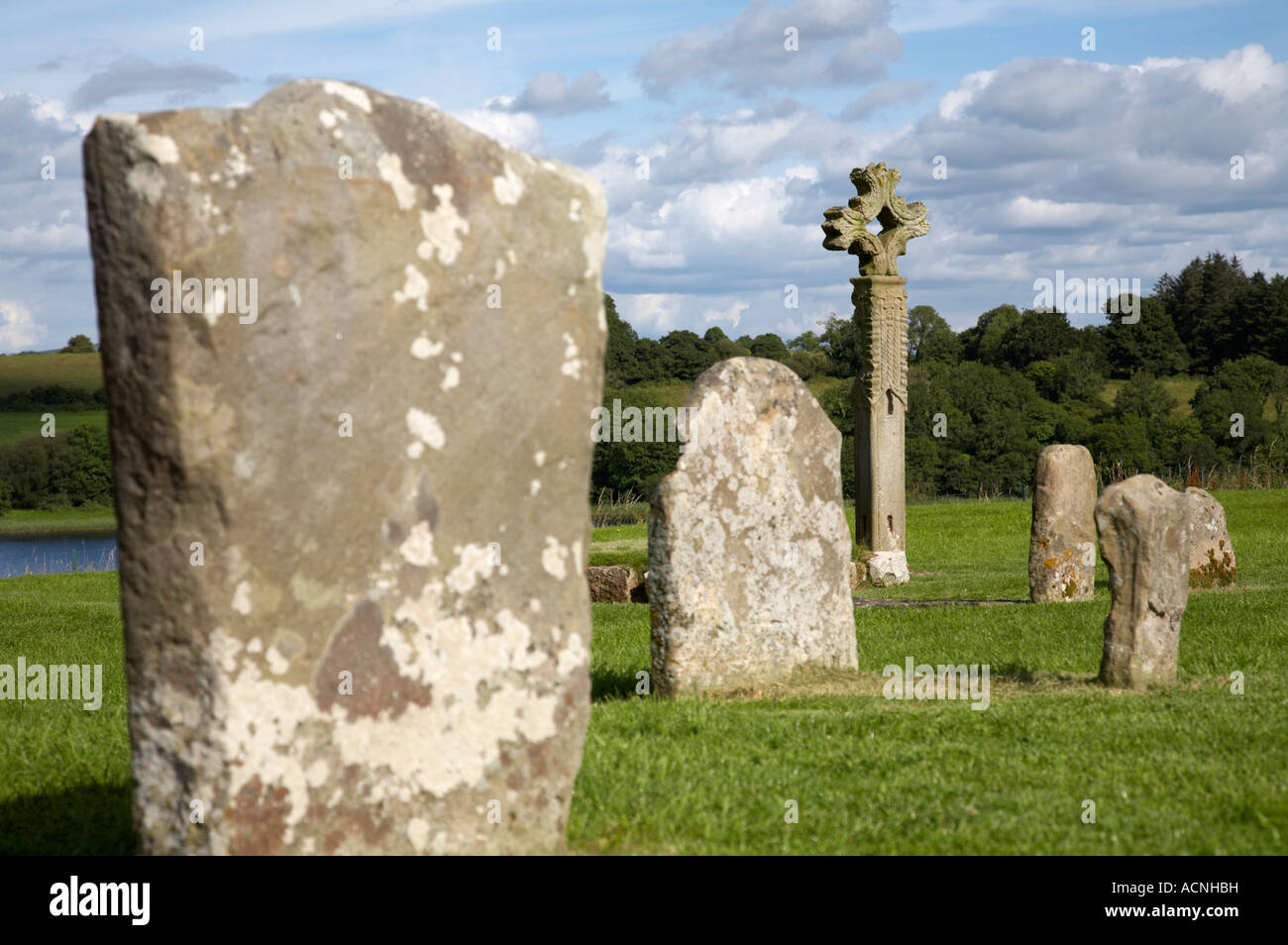 gravestones and mid 15th century high cross in the graveyard on devenish island Stock Photo