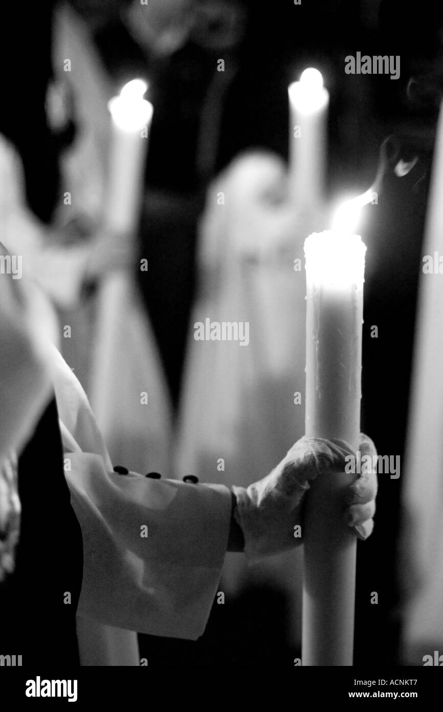 Penitents holding candles during an Easter procession, Seville, Spain Stock Photo
