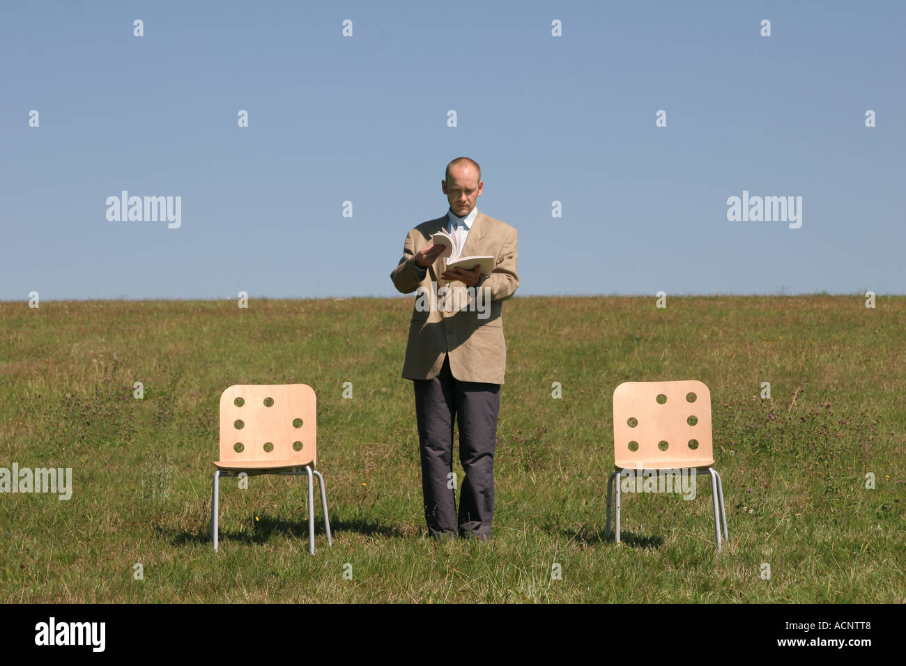 businessman to be caught between two stools - Geschäftsmann zwischen den Stühlen Stock Photo