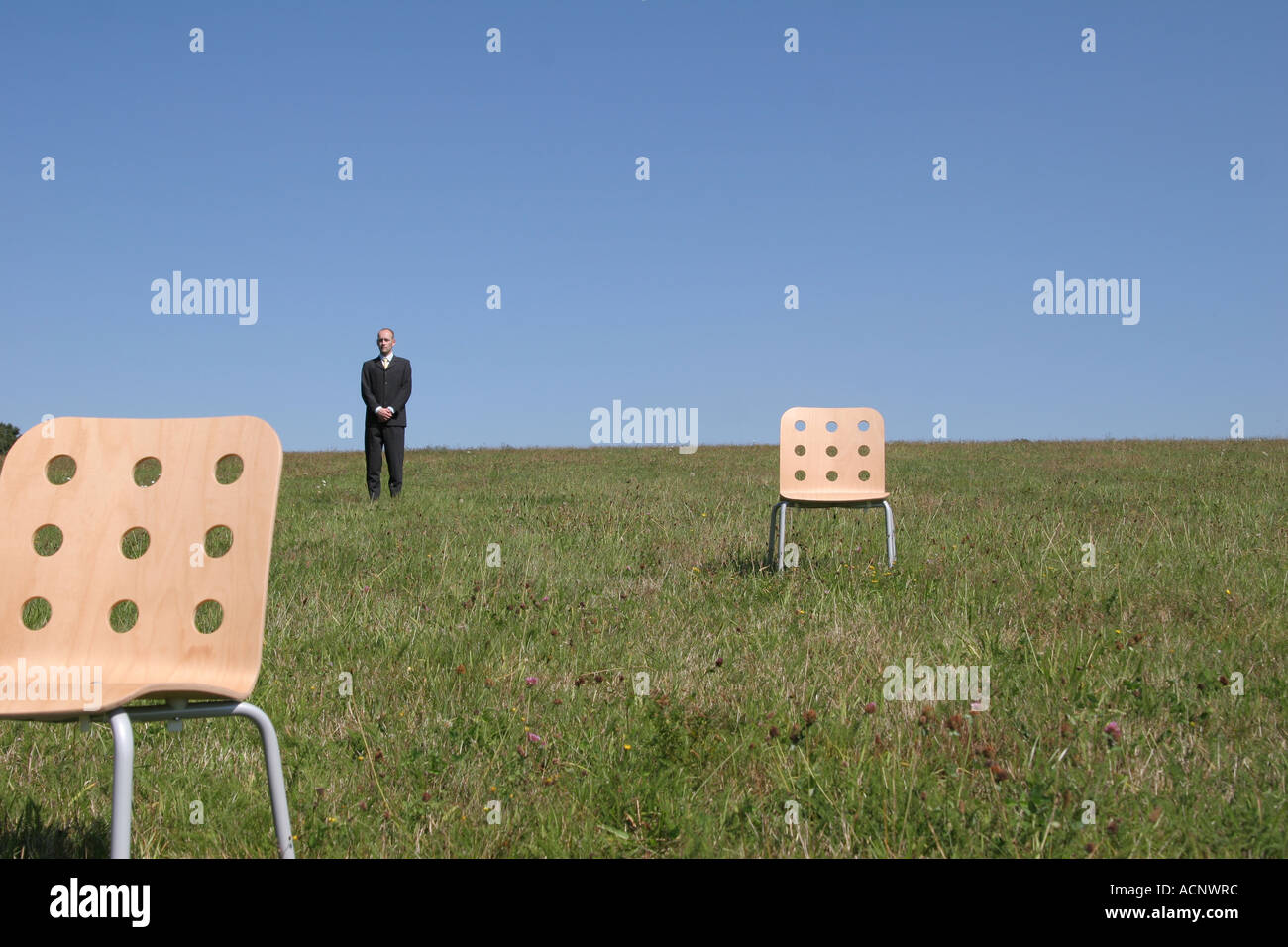 Businessman behind stools on the meadow - Geschäftsmanau einer Wiese Stock Photo