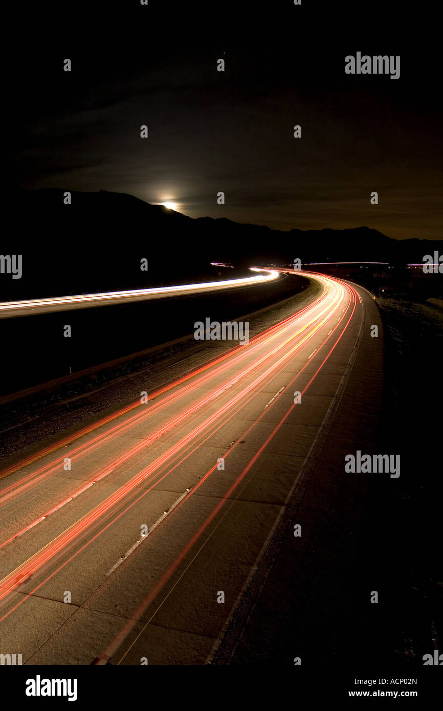 Vertical view of traffic speeding along California's US 101 on the Pacific Coast as night falls and the moon rises Stock Photo
