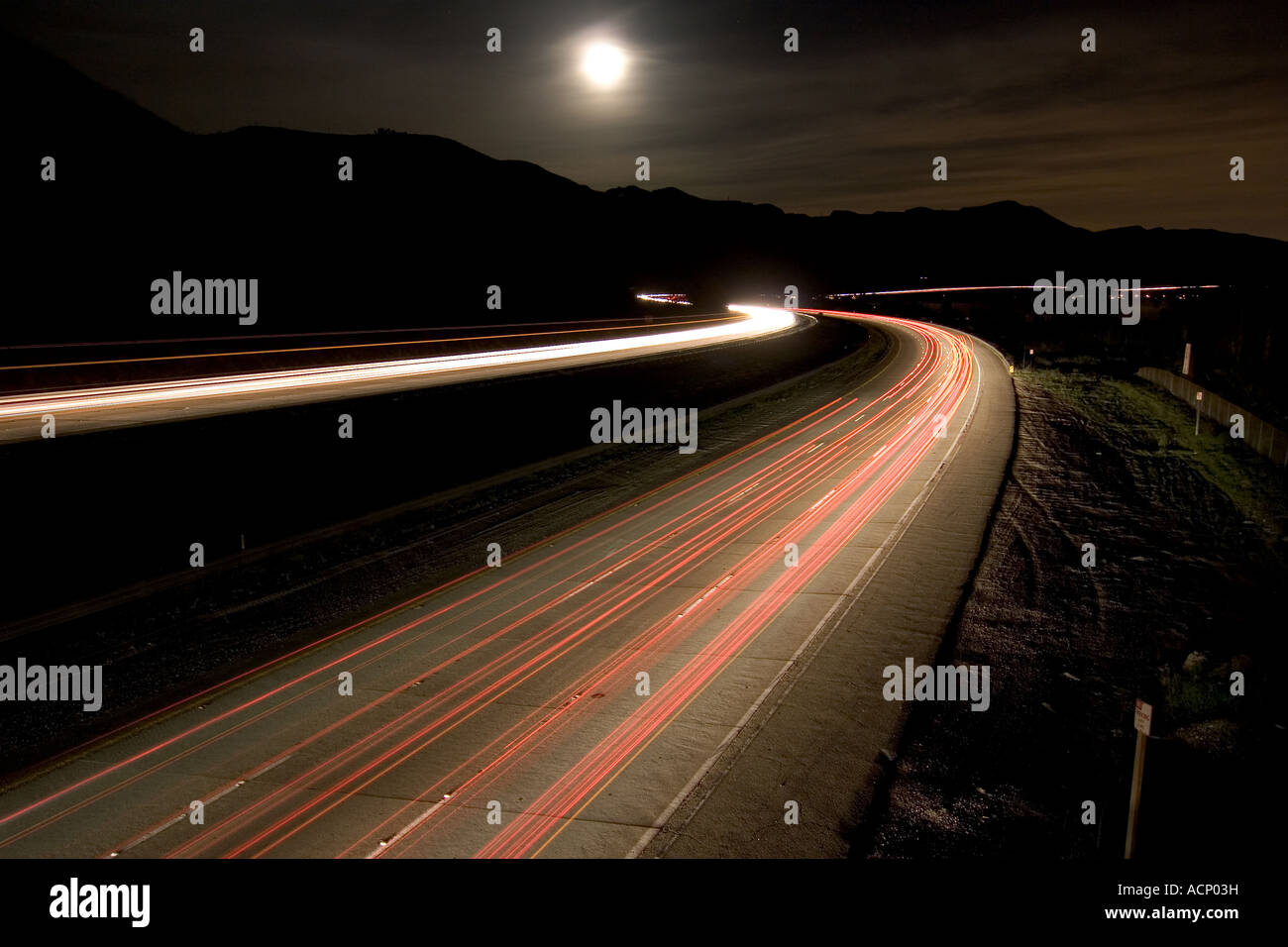 Moonrise over traffic on the 101 freeway in Ventura County, California Stock Photo