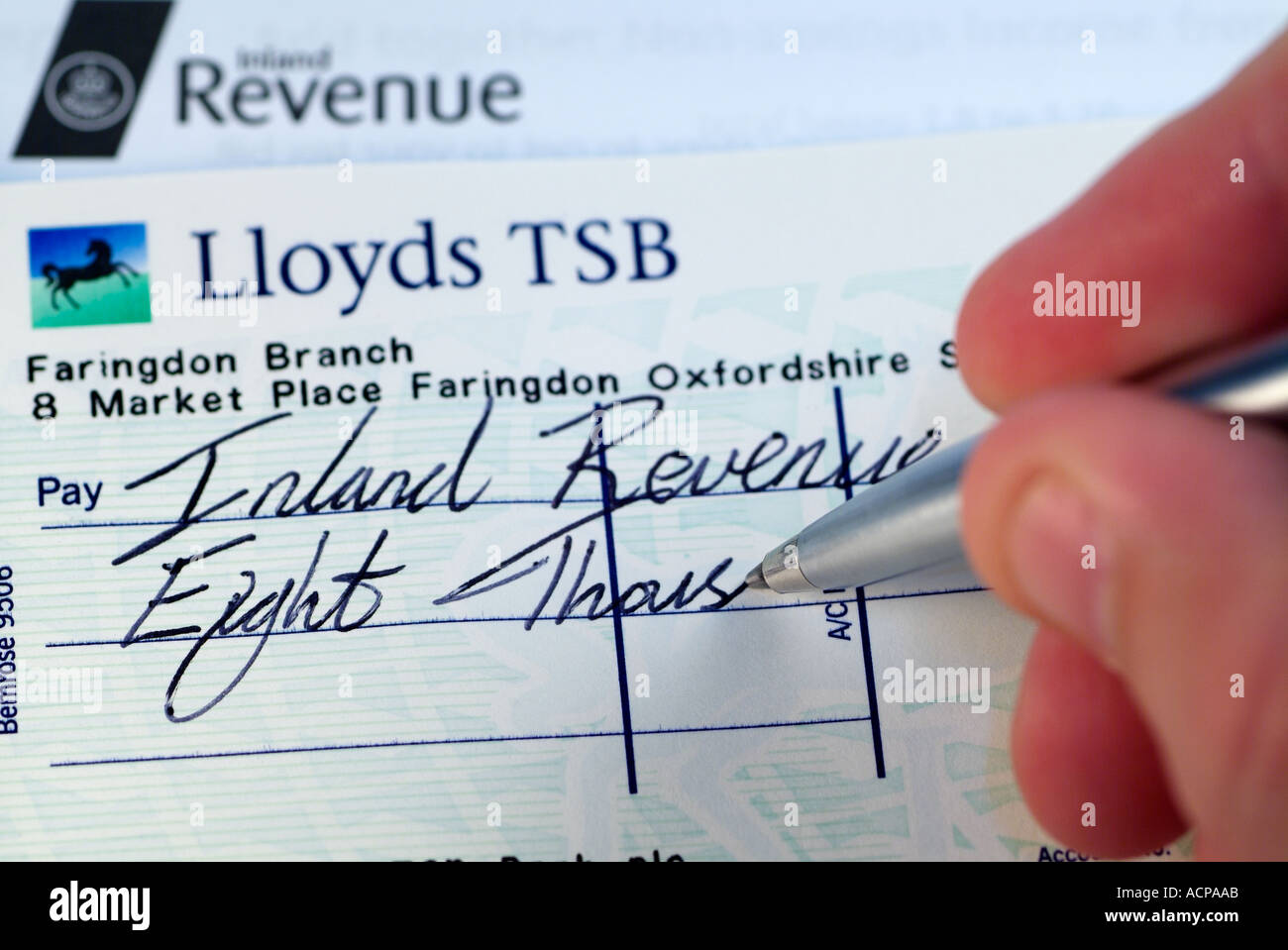 Writing a Cheque to the United Kingdom Inland Revenue to Pay a Tax Bill, Close Up. Stock Photo