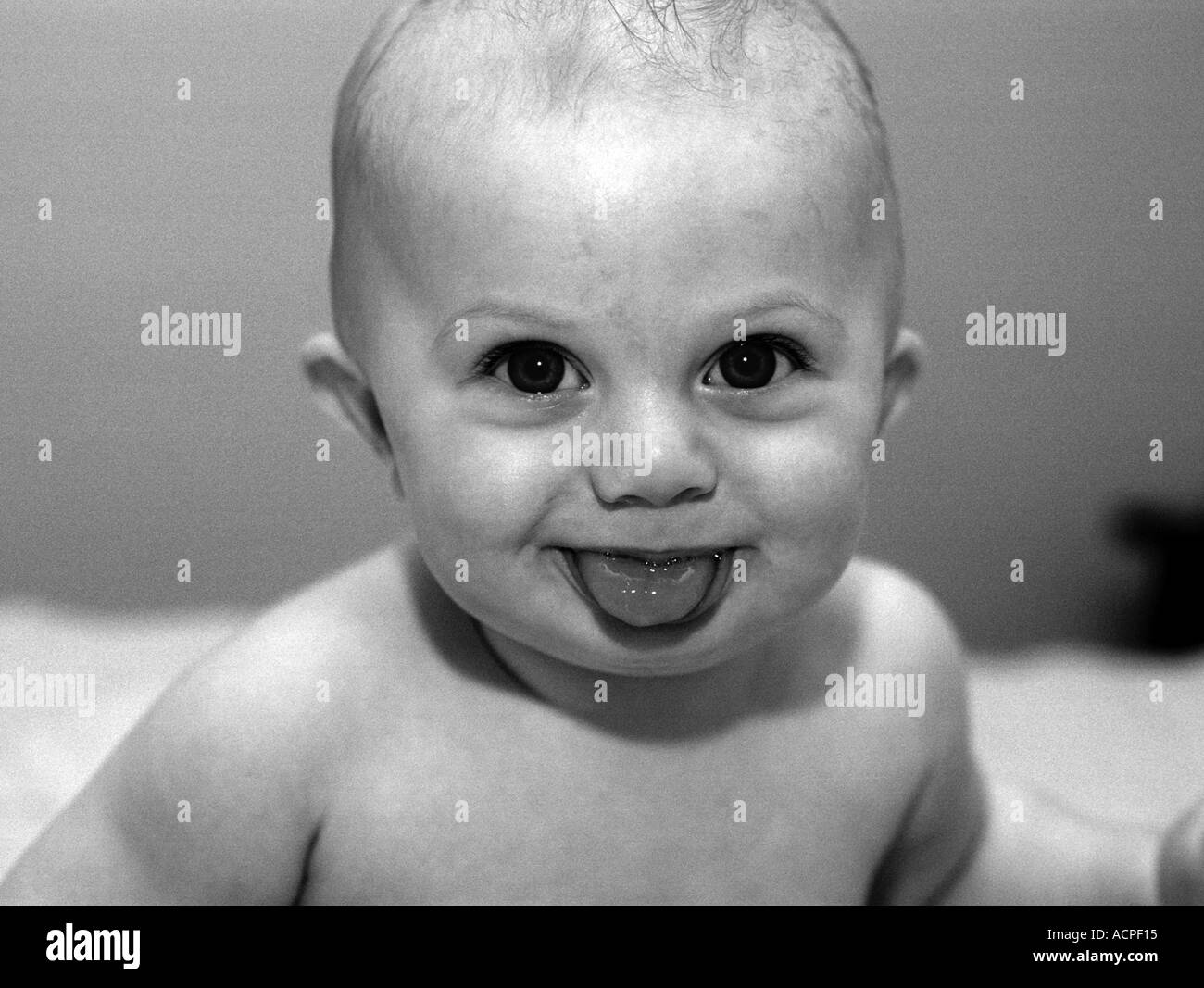 small baby boy making funny face with tongue out blowing rasberry Stock Photo