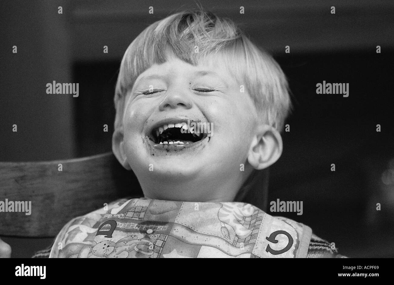 small boy laughing with food on face humor Stock Photo