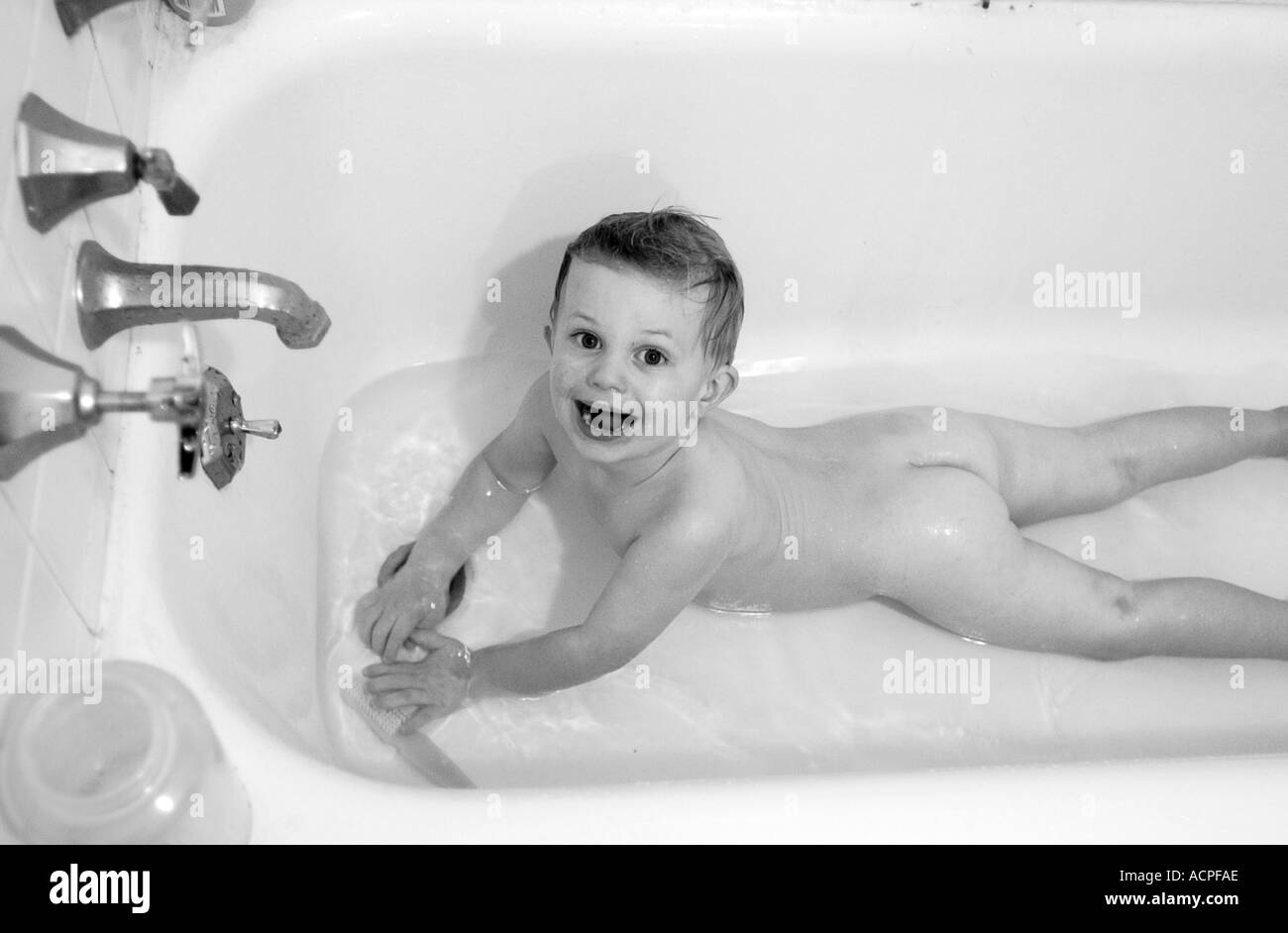 Small baby boy in tub playing in tubby Stock Photo