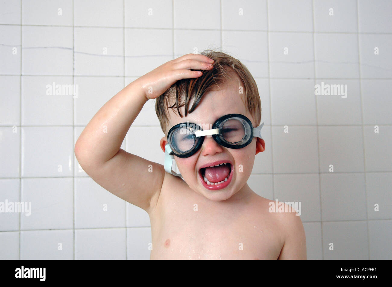 Small boy in tub wearing swimmers goggles making funny face. Stock Photo