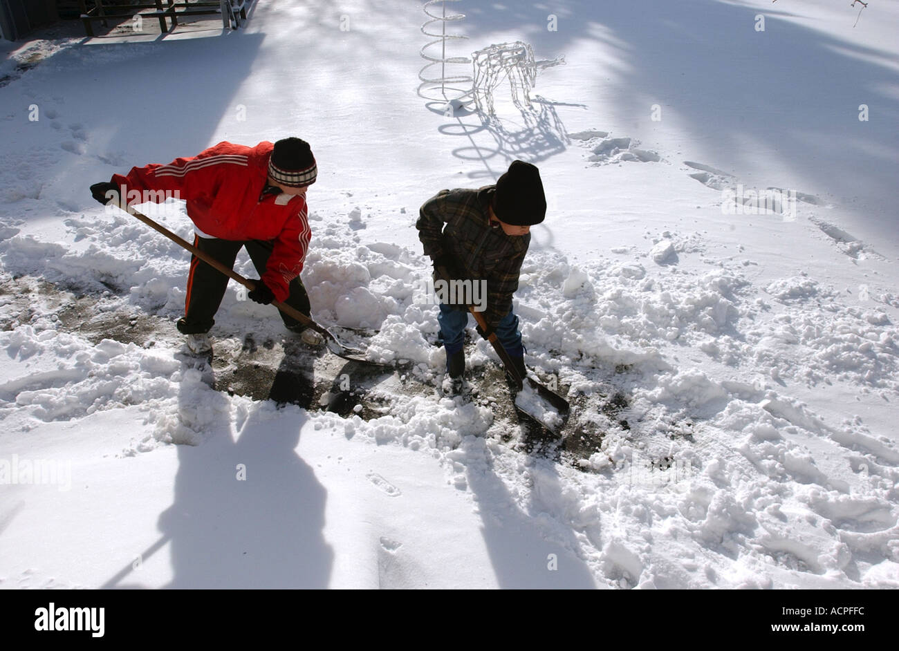 Two boys shoveling snow shovel snow Stock Photo