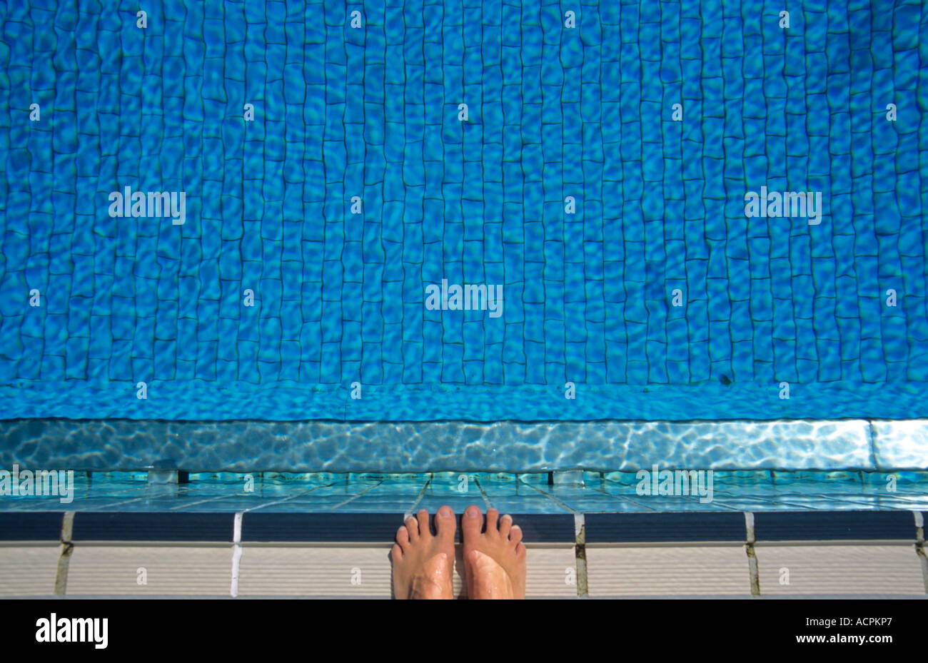 Feet at edge of swimming pool, elevated view Stock Photo - Alamy