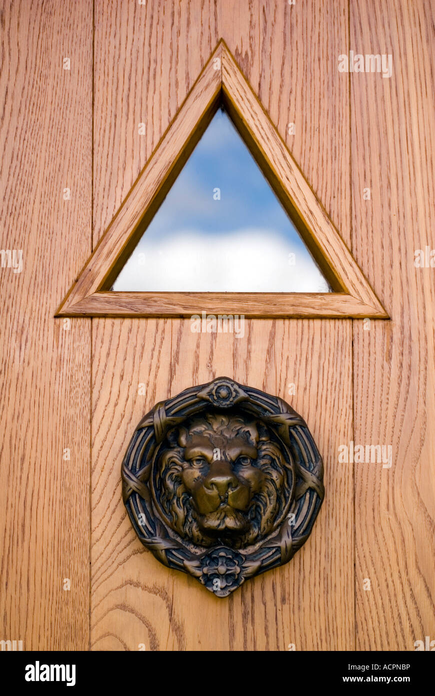 Brass door knocker in the form of a lions head on a wooden door at Amaravati Buddhist Monastery England Great Britain Stock Photo