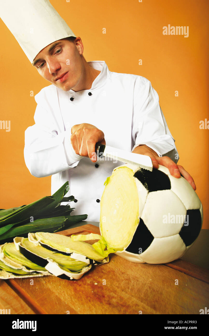 Cook slicing football shaped cabbage Stock Photo