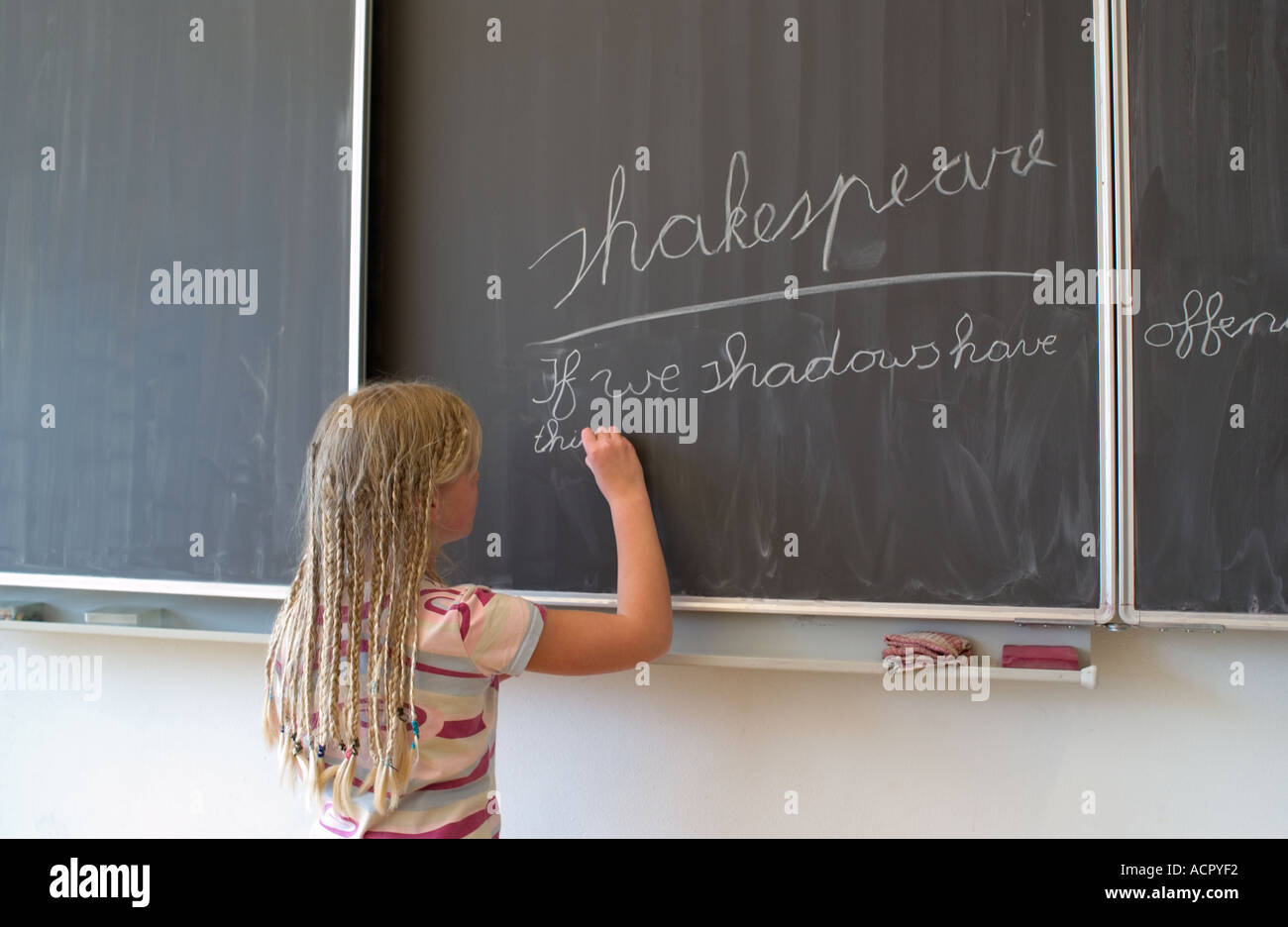 Girl writing on a blackboard in elementary school Stock Photo