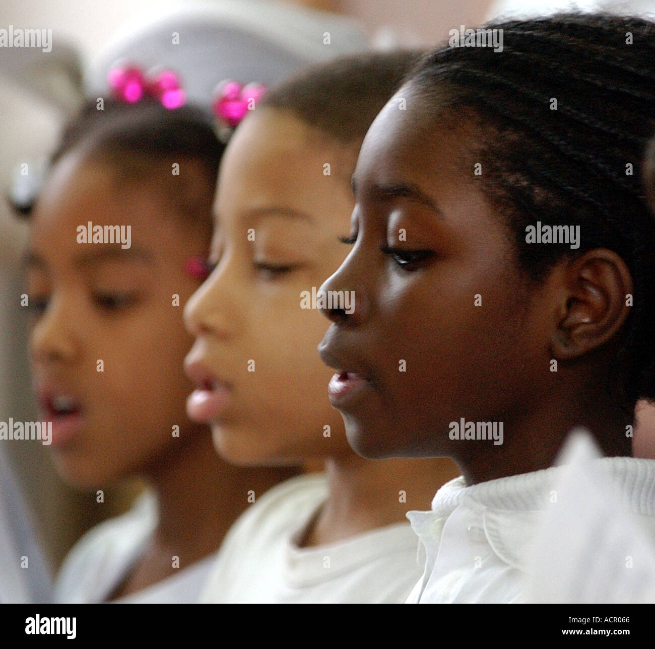 Three African American girls sing in a school choir Stock Photo