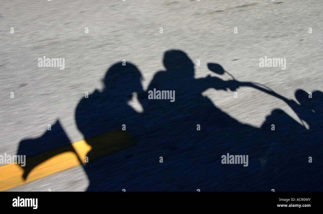 Shadow of Motorcycle Riders on Roadway Stock Photo