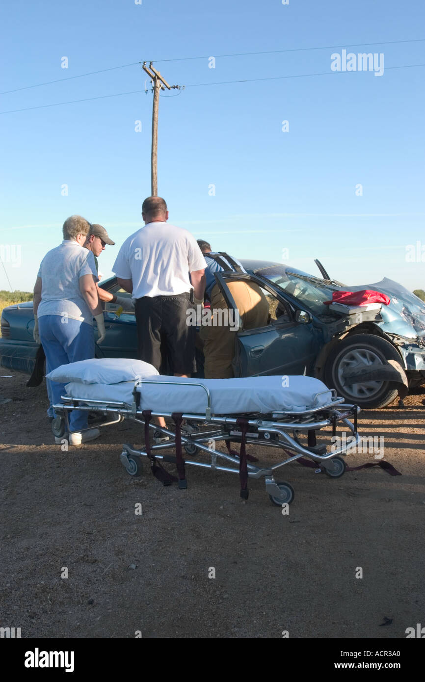 Traffic accident. EMTs attending to injured passenger. Crash on rural road, serious injury accident. Stock Photo
