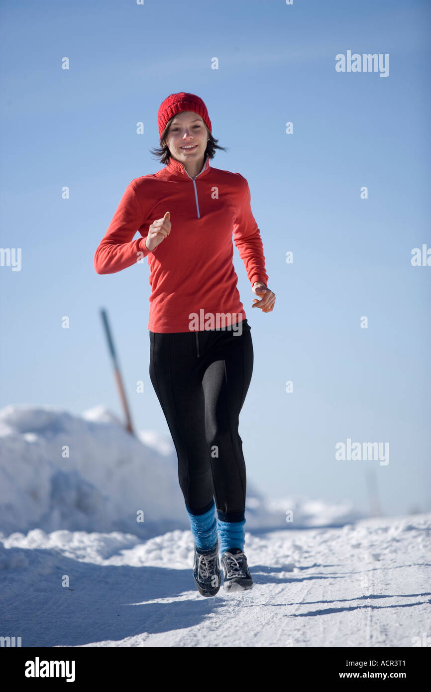 Young woman jogging in snow Stock Photo