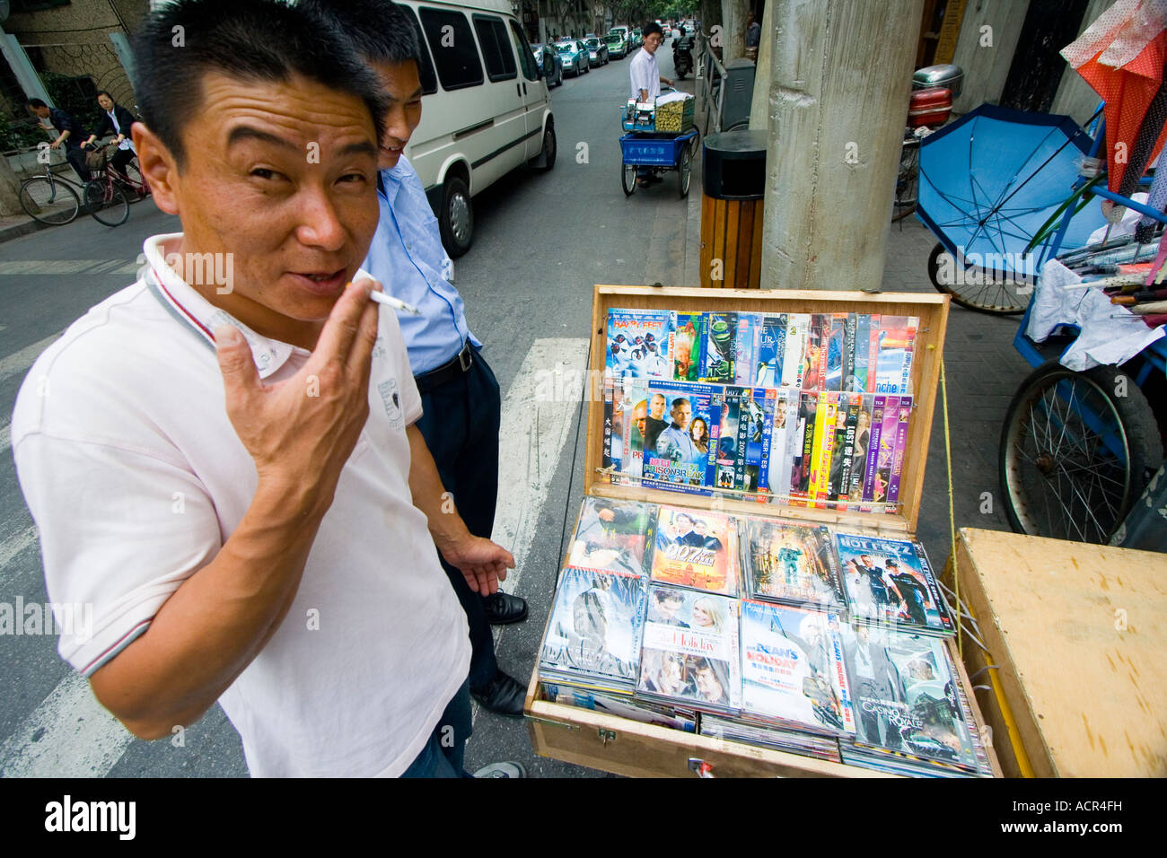 Chinese Man Selling Fake Counterfeit DVDs on the Street Shanghai China Stock Photo