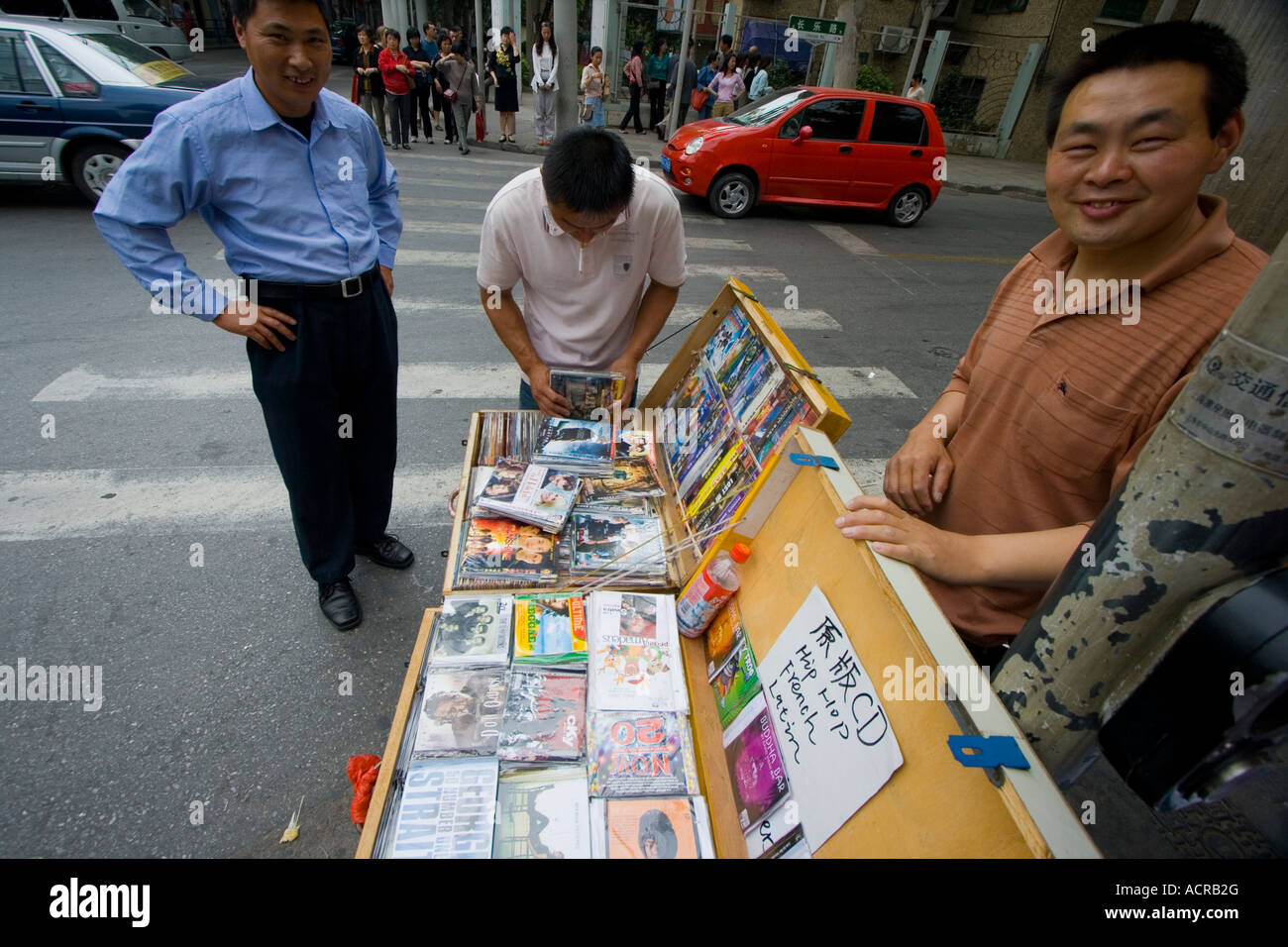 Chinese Man Selling Fake Counterfeit DVD Movies and Music CDs on the Street Shanghai China Stock Photo