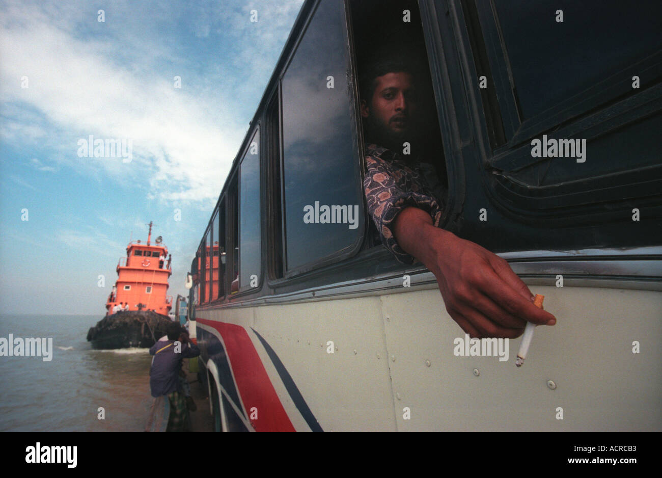Bangladesh man sitting on bus whilst being transported on a ferry Stock Photo