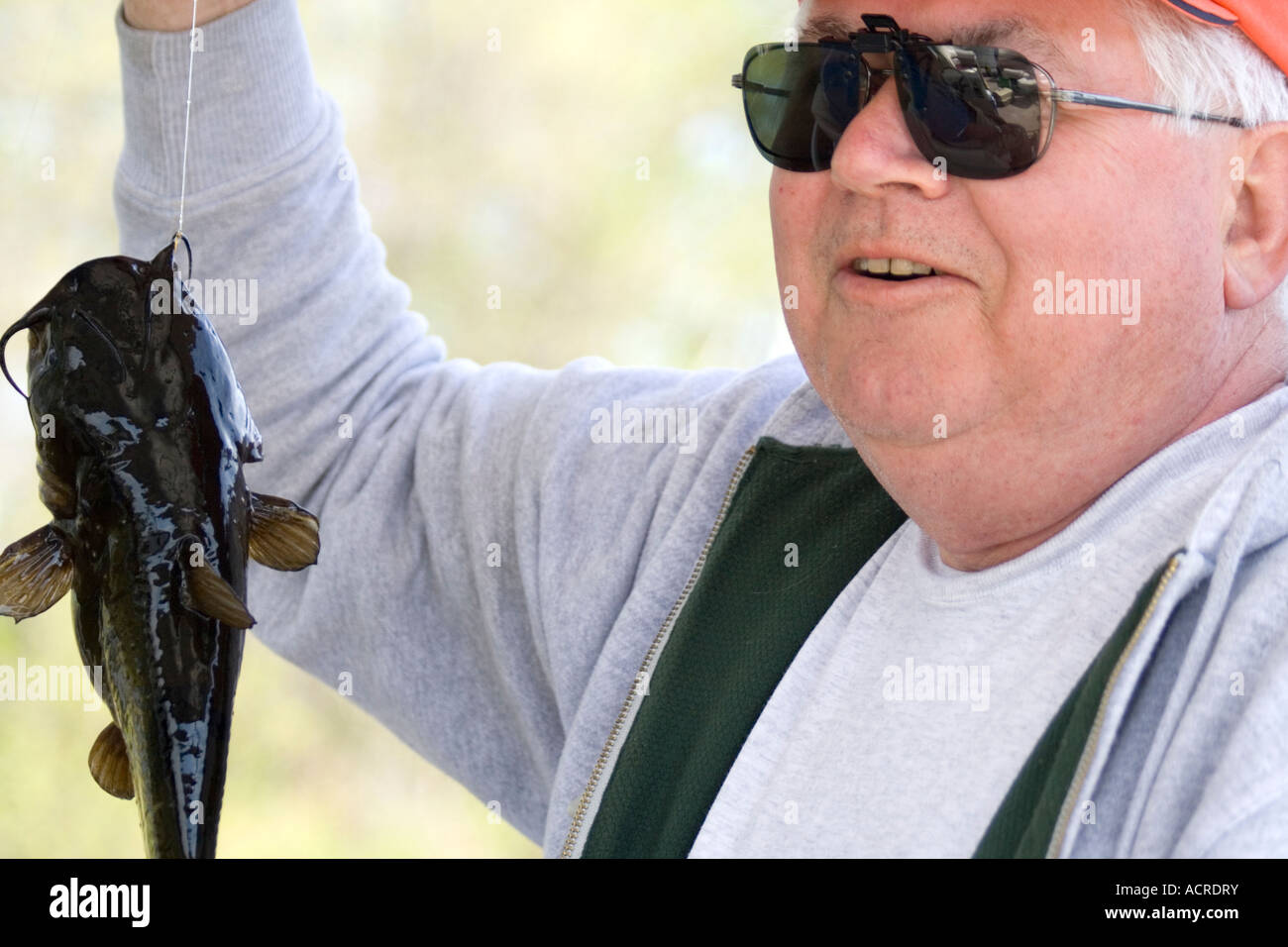 Angler just glad to hold up his first fish even though its a bullhead. Gull Lake Nisswa Minnesota USA Stock Photo