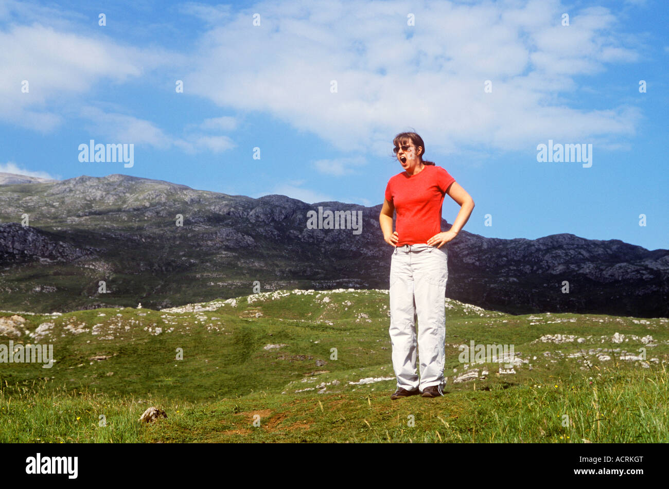 Woman in Scottish countryside yawning Stock Photo