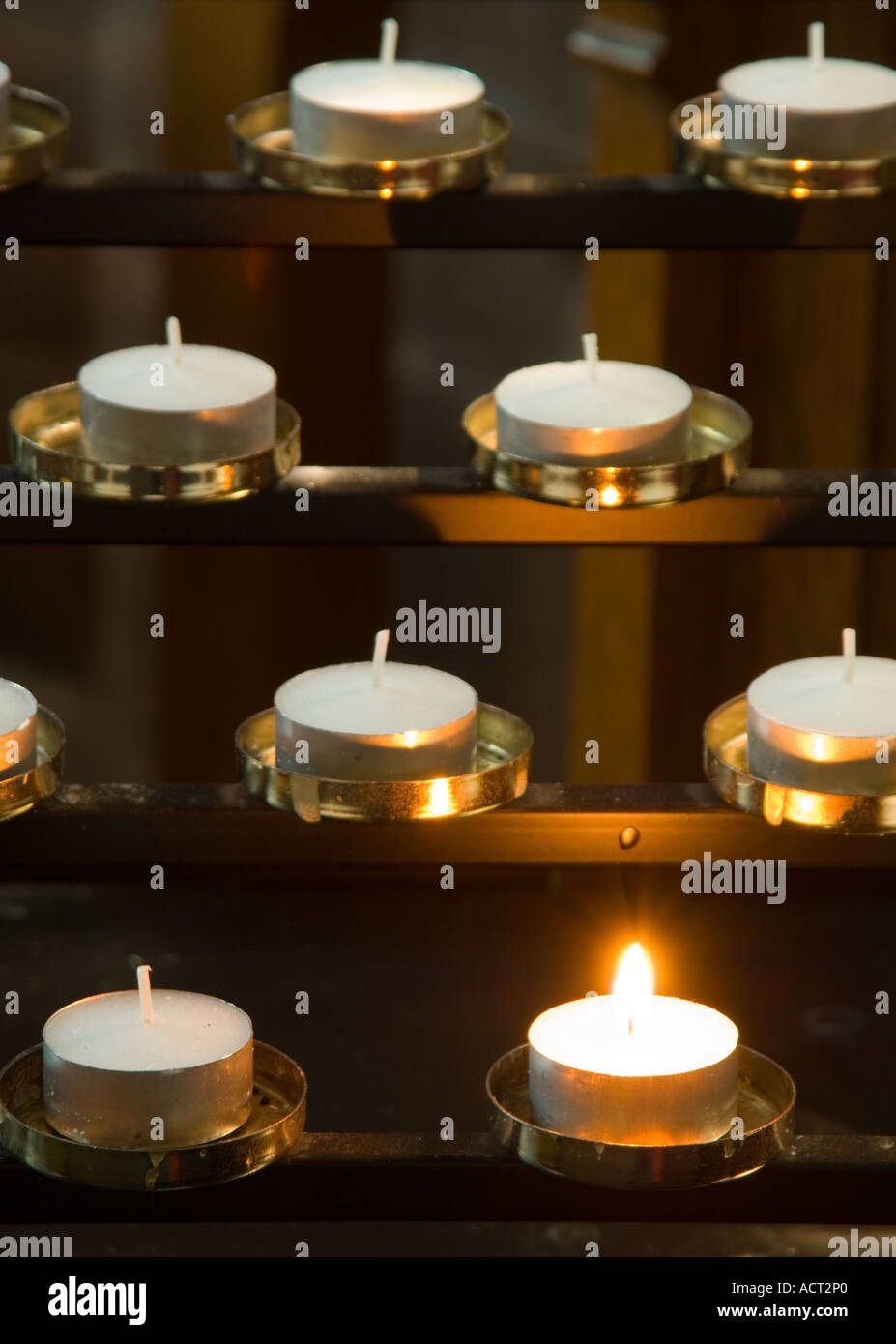 Single Church Candle Burning Amongst a Multitude of Others Stock Photo