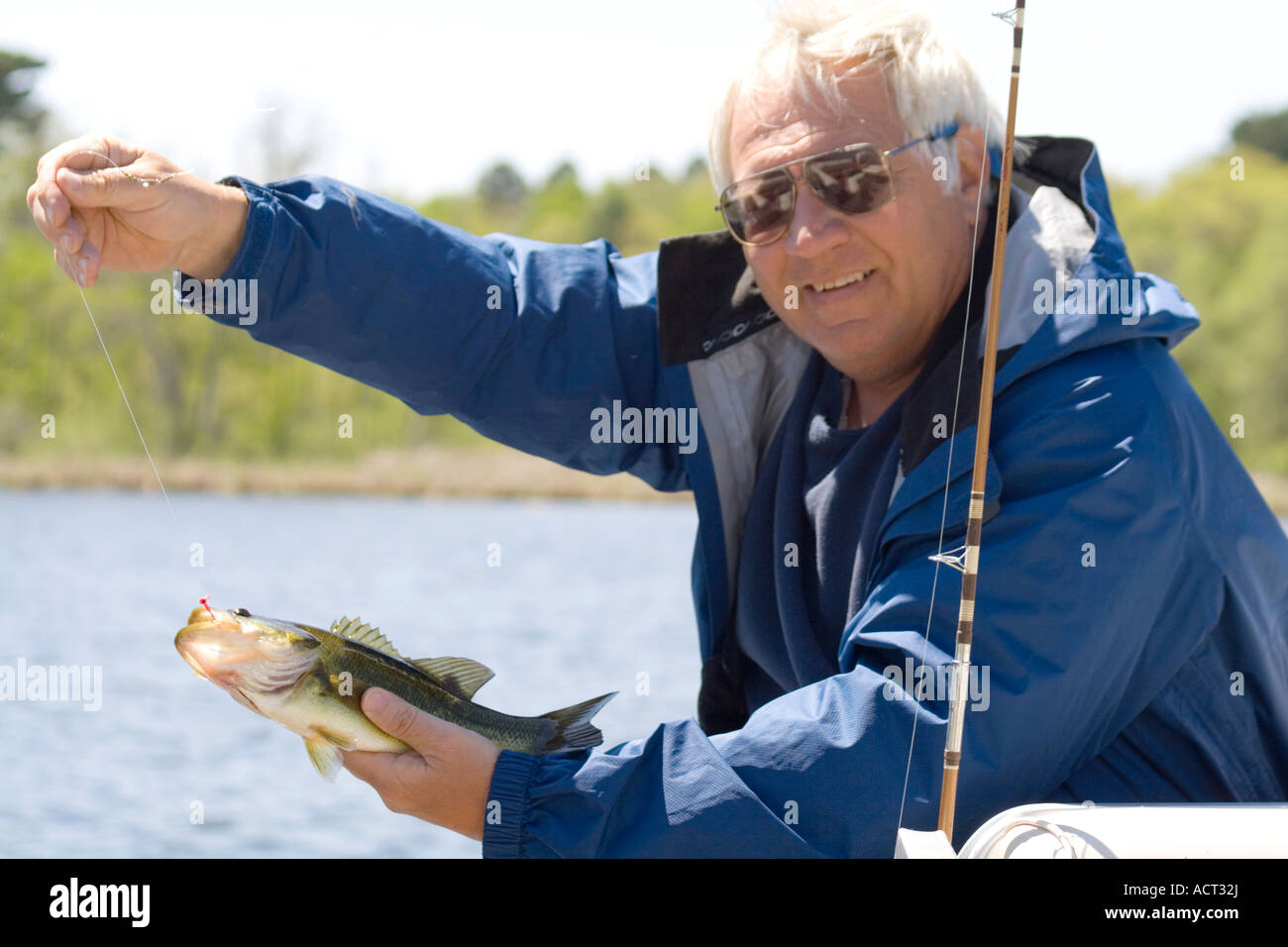 Proud angler holding up his catch and release large mouth bass Micropterus salmoides. Gull Lake Nisswa Minnesota USA Stock Photo