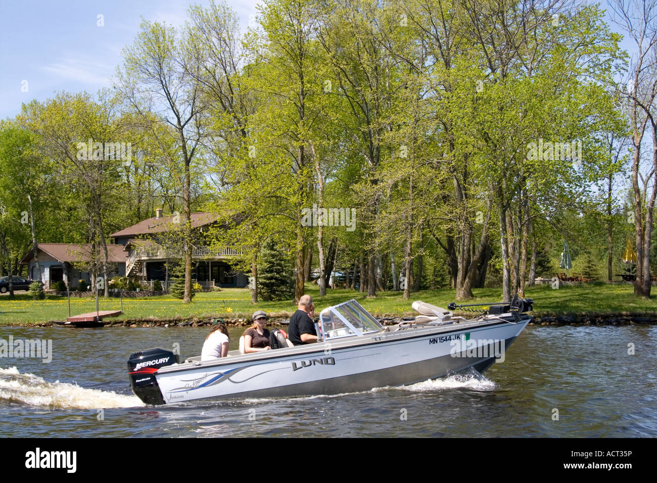 Family in a Lund fishing boat propelled by a Mercury outboard motor. Gull Lake Nisswa Minnesota USA Stock Photo