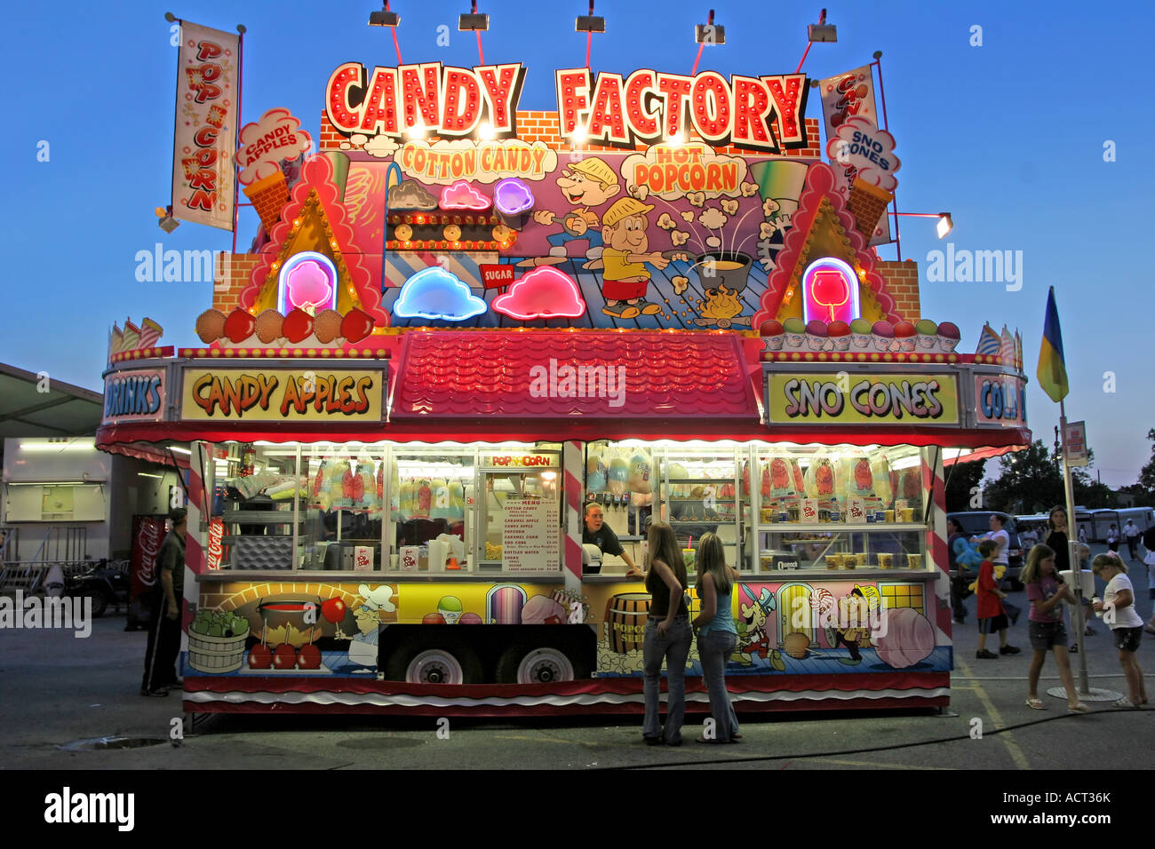 Two women buy something at the "Candy Factory", a food stand at the