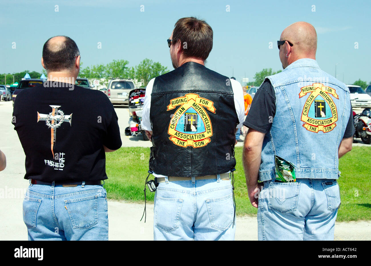 Christian motorcycle club emblems on the backs of three participants