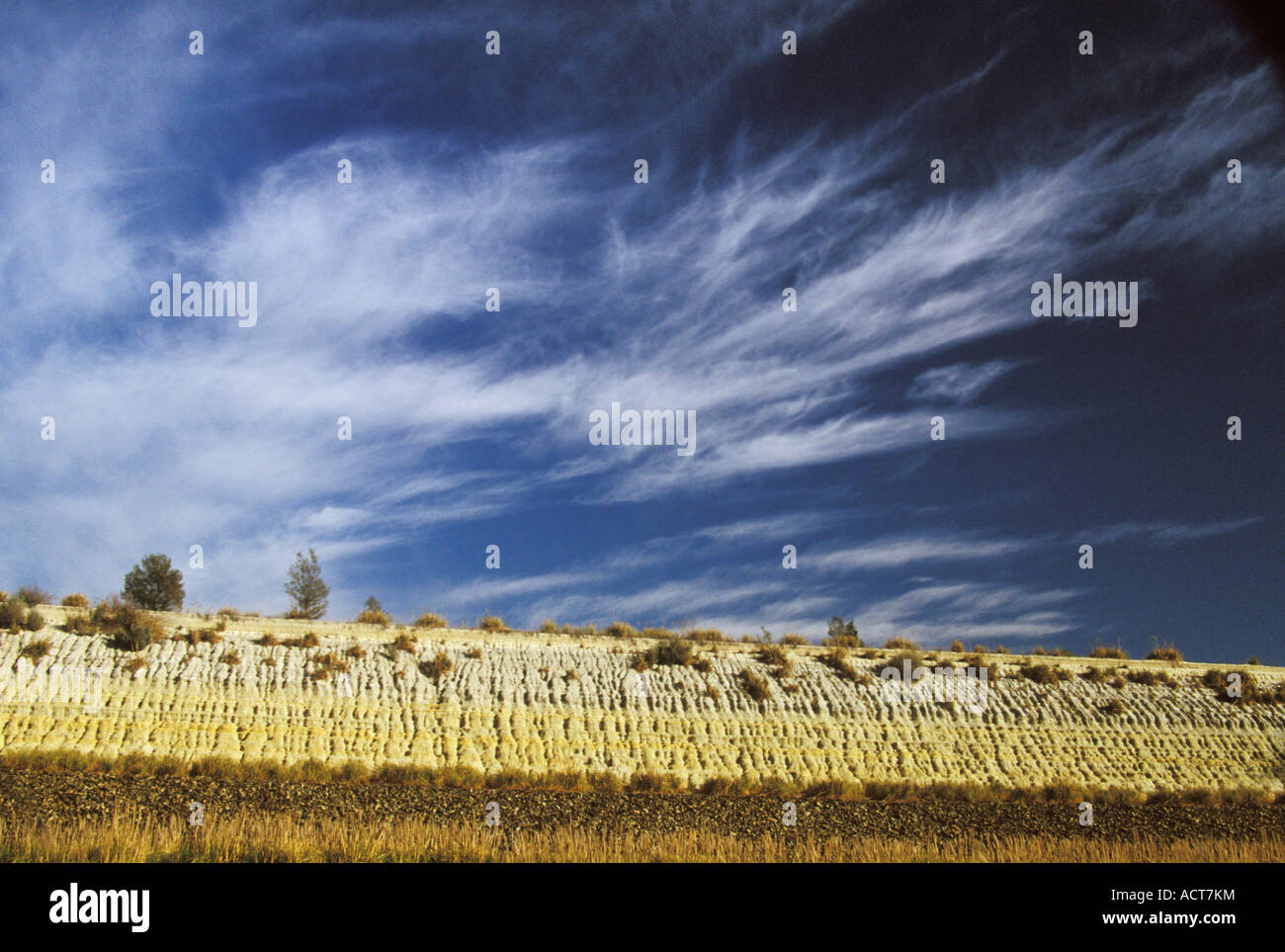 A reclaimed mine dump viewed against a deep blue sky with swirling clouds Gauteng South Africa Stock Photo