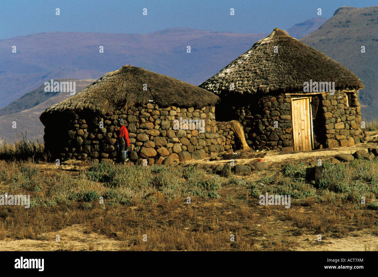 Traditional stone and thatch homesteads built on the escarpment in the Lesotho hills Lesotho Stock Photo