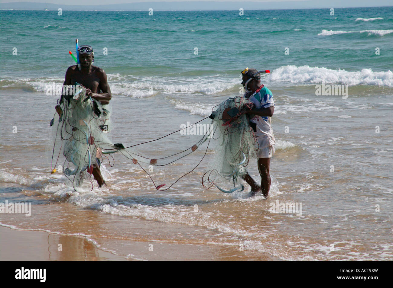 Tow local fishermen dragging a net from the sea onto the beach Barra Inhambane Province Mozambique Stock Photo