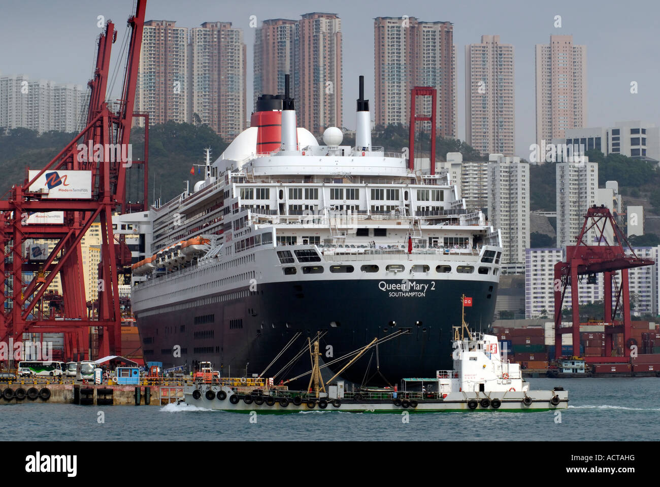 The Queen Mary 2 docked at a container terminal in Hong Kong Stock