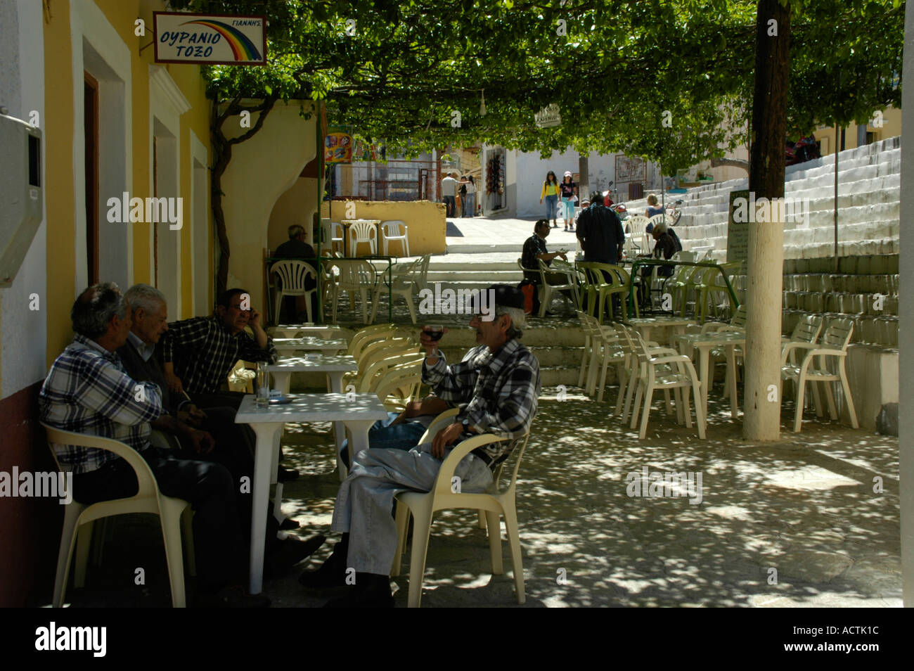 Old men sit together in the shade of a taverna Georgios Island of Symi Greece Stock Photo