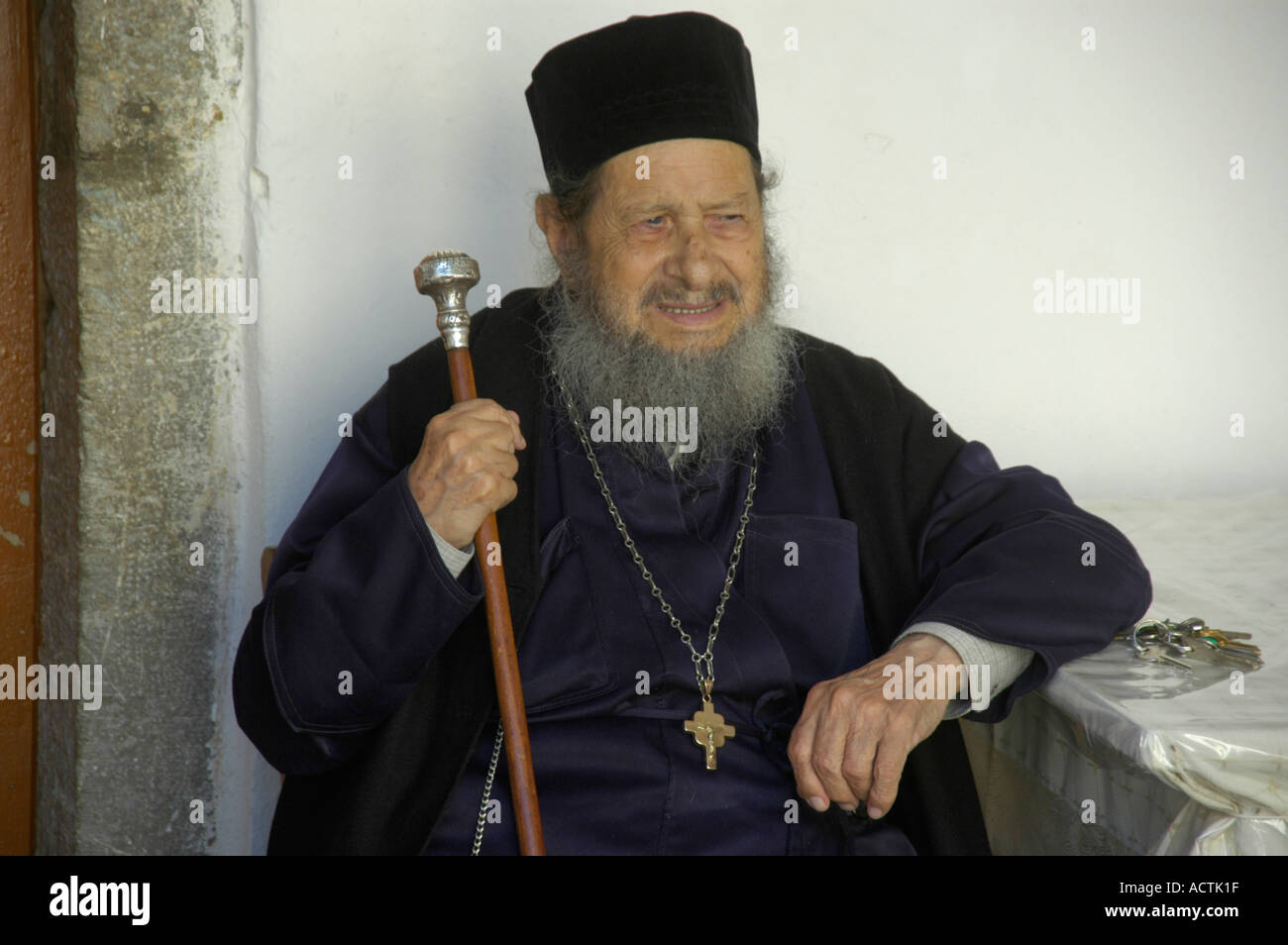 Portrait Black dressed Greek Orthodox clergyman wearing hat beard stick and cross the Monastery Panormitis Island of Symi Greece Stock Photo