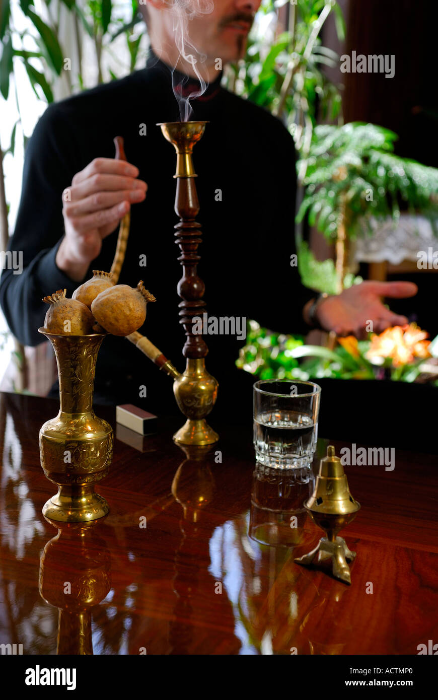 Man talking drinking and smoking a hookah water pipe Stock Photo