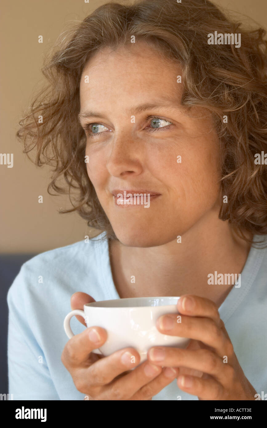 Blond woman smiling with a cup of tea Stock Photo