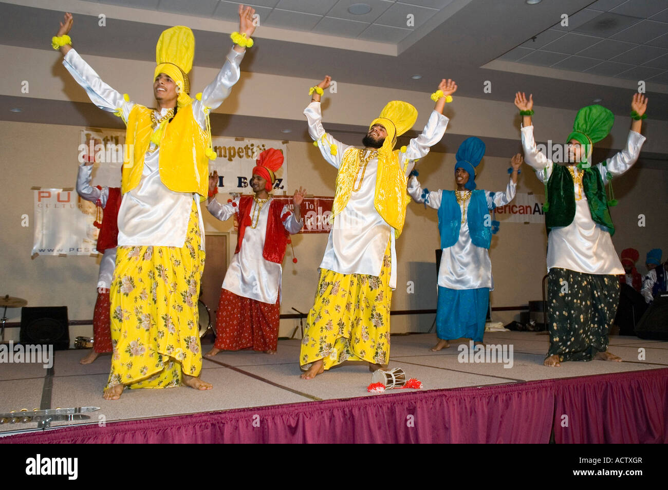 BHANGRA DANCERS IN MULTI COLOR DRESSES WITH ARMS UP IN AIR Stock Photo ...