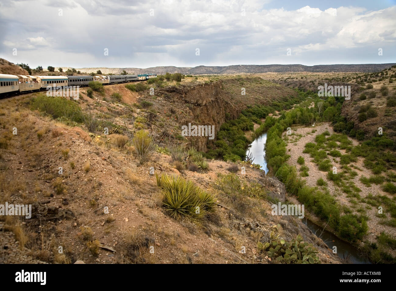 Verde Canyon Railroad cars rounding a bend next to curving river, Verde