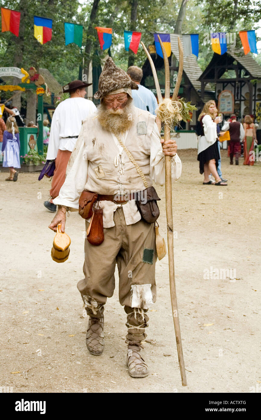 A Bum man walking in the road holding a forked staff in his hand Stock ...