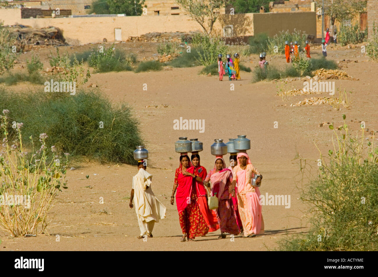 A group of Rajasthani village women collecting water 1 km from their village in the Thar desert about 40km from Jaisalmer. Stock Photo