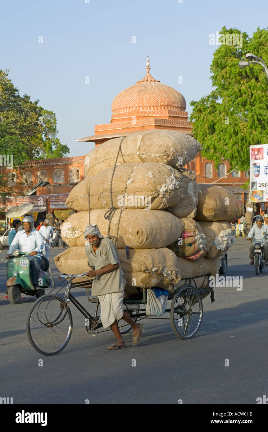 An overloaded cycle rickshaw being pushed through the streets of Jaipur. Stock Photo