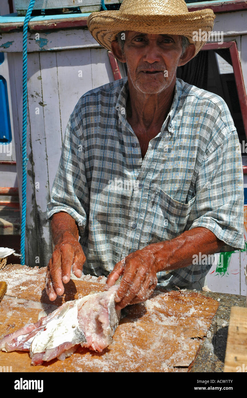Fisherman adding salt to preserve Amazon River Brazil Stock Photo