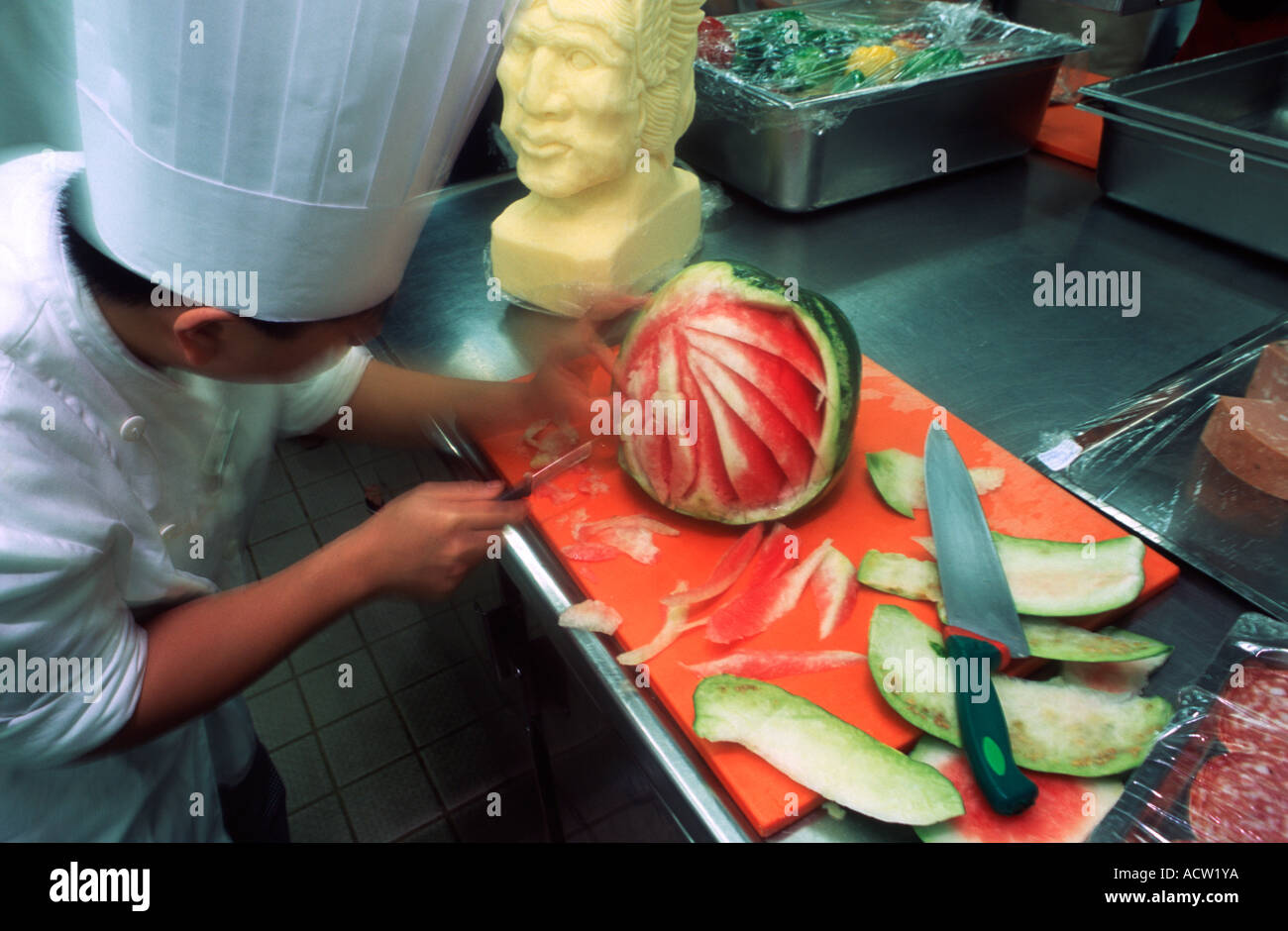 A Filipino chef carves a watermelon to create an elaborate design, a practice known as fruit carving. Stock Photo