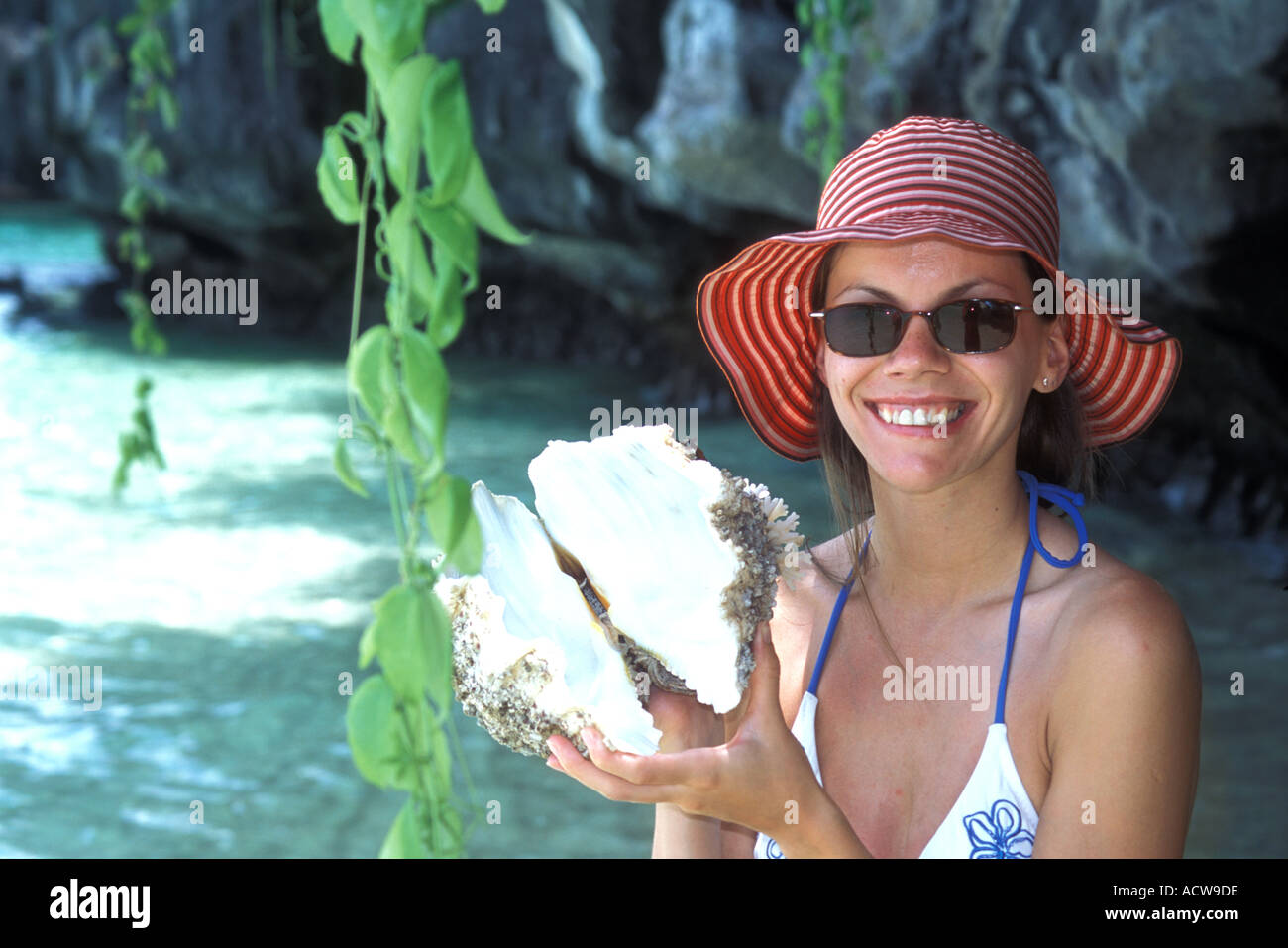 Philippines Palawan A tourist holds up the shell of a giant clam on one ...