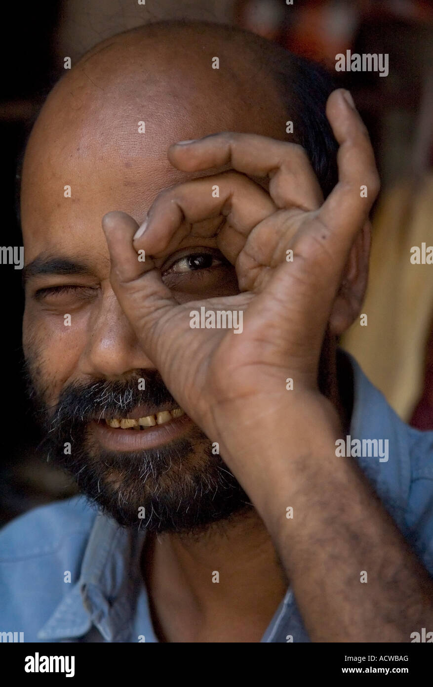 indian-man-peeking-through-a-hole-varanasi-benares-india-ACWBAG.jpg